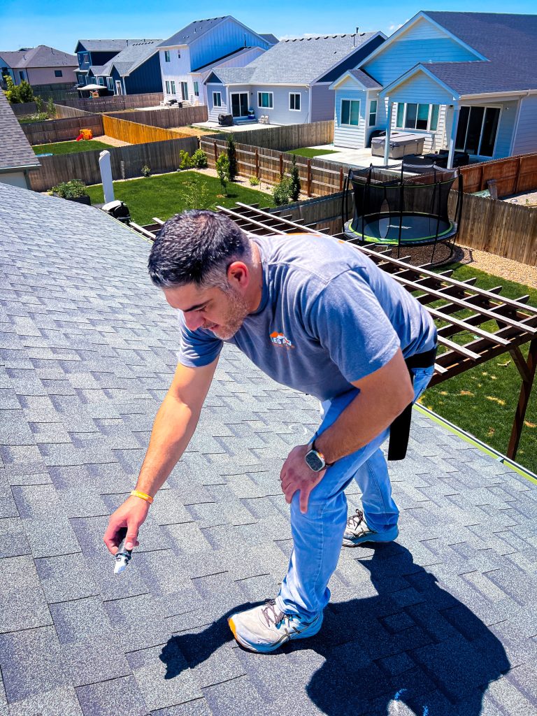 Julian doing an inspection in Milliken roof after hail storm