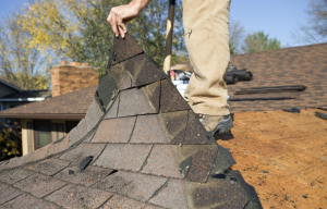 Roof replacement removing damaged shingles by Legacy Roofers